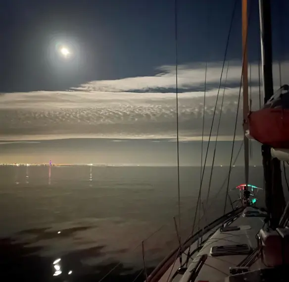 Yacht under sail at night during RYA Coastal Skipper training passage