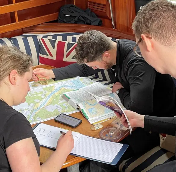 RYA Coastal Skipper instructor briefing crew before passage planning exercise.