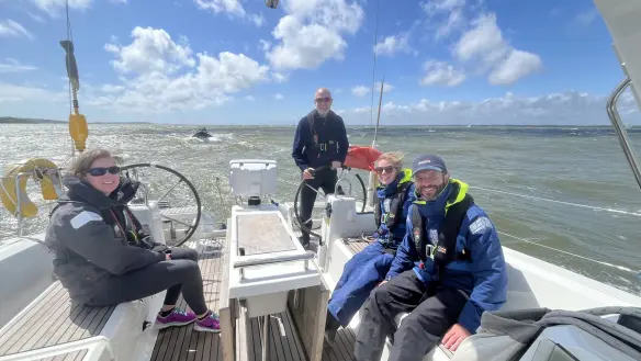 RYA Day Skipper student helming yacht during daytime training in Southampton.