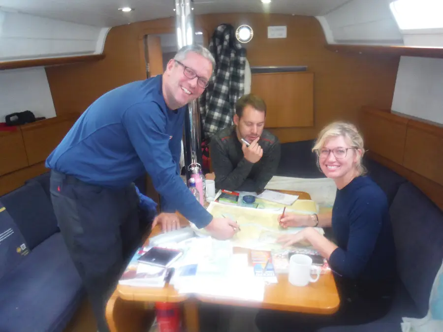 Sailors marking waypoints on a Channel Triangle passage plan