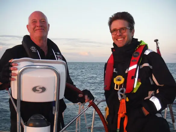 Instructor guiding small crew on RYA Competent Crew Course in autumn.