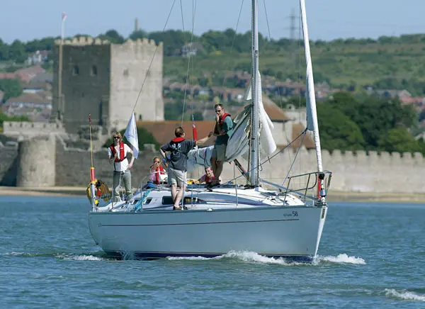 Group of RYA students smiling on deck after completing sailing training on the Solent