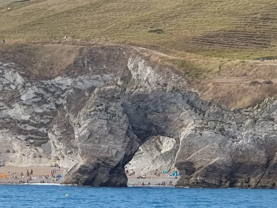 Sailing yacht passing Durdle Door on a Dorset Jurassic Coast cruise